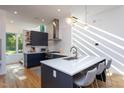 Bright kitchen features navy cabinets, quartz countertops, stainless appliances, and pendant lighting at 414 Chavis Way, Raleigh, NC 27601