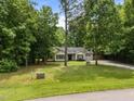 Ranch-style home with well-manicured lawn and a long gravel driveway surrounded by mature trees at 4508 Alice Dr, Oxford, NC 27565