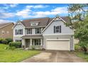 Two-story home with grey siding, black shutters, and a two-car attached garage at 5025 Stonewood Pines Dr, Knightdale, NC 27545