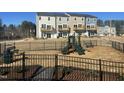 Community playground and view of townhomes with balconies in a well-maintained neighborhood at 5029 Jowetts Walk Dr # 29, Cary, NC 27519