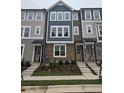 New construction townhome featuring a stone facade, blue accents and crisp white-framed windows at 5029 Jowetts Walk Dr # 29, Cary, NC 27519