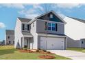 Traditional two-story home featuring gray siding, a two-car garage, and a green lawn at 51 Crow Field St, Roxboro, NC 27574