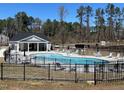 Community pool with ample seating and a covered area for relaxing, surrounded by a black metal fence at 6010 Shade Tree Ln, Durham, NC 27703