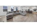 Spacious living room with large sectional sofa, hardwood floors, and natural light, ideal for entertaining at 604 Salmonberry Dr, Holly Springs, NC 27540