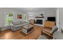 Cozy living room features fireplace, hardwood floors, neutral paint and an abundance of natural light at 6717 Ebon Ct, Raleigh, NC 27615