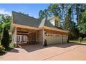 Spacious three-car garage with an open covered area for parking with stone accents and a brick exterior at 71012 Russell, Chapel Hill, NC 27517