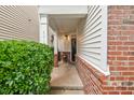 Inviting covered front porch with brick accents and elegant columns, leading to a black front door at 8013 Morrell Ln, Durham, NC 27713