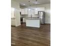 Bright, open kitchen with white cabinets, stainless steel appliances, and center island with granite countertop at 805 Da Vinci St, Durham, NC 27704