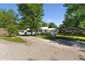 Traditional home featuring a gravel driveway, carport, and well-manicured front lawn at 8089 Crawford Currin Rd, Oxford, NC 27565