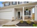 Inviting front porch with bench, hanging flower basket, and manicured landscaping at 95 Buckthorn Dr, Youngsville, NC 27596