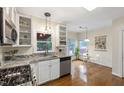 Bright kitchen with granite countertops, white cabinetry, stainless steel appliances, and breakfast nook at 102 W Hill Dr, Cary, NC 27519