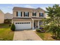 Lovely two-story home with manicured landscaping, a covered front porch, and a convenient two-car garage at 105 Putters Ct, Durham, NC 27703