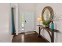 Welcoming foyer with wood floors, console table, decorative mirror, and bright natural light at 105 Putters Ct, Durham, NC 27703