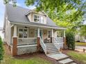 Charming exterior view featuring a covered front porch with white railings, and a inviting staircase at 10579 Evergreen Spring Pl, Raleigh, NC 27614