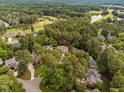 An aerial view showcases the property nestled among lush trees with a golf course and pond nearby at 108 Vescova Ln, Morrisville, NC 27560