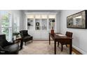 Cozy office features custom built-in shelving with decorative items, a desk, and comfortable seating at 108 Vescova Ln, Morrisville, NC 27560