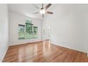 Spacious living room with hardwood floors, a ceiling fan, and large windows for plenty of natural light at 111 Catherwood Pl, Cary, NC 27518
