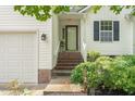 Exterior view showcasing the front door with brick steps and adjacent two-car garage at 1113 Pilton Pl, Raleigh, NC 27604