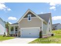 Well-maintained home features an attached two-car garage, a welcoming porch, and neat landscaping at 112 Cultivator Ct, Angier, NC 27501