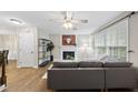 Cozy living room features a fireplace, ceiling fan, and large windows for natural light at 1200 Collington Dr, Cary, NC 27511