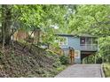View of home exterior featuring covered parking, a screened-in porch, wood steps, and hillside landscaping at 126 Weaver Rd, Chapel Hill, NC 27514