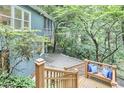 Elevated view from the deck featuring outdoor bench seating with blue pillows, lush greenery, and scenic views at 126 Weaver Rd, Chapel Hill, NC 27514