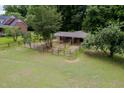View of a well-maintained barn with fenced paddocks, offering secure and spacious accommodations for livestock at 12823 Summerwind Trl, Rougemont, NC 27572