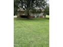 A large grassy backyard featuring an exterior deck and tree coverage at 1942 Brier Ln, Graham, NC 27253