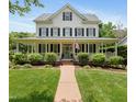 Inviting two-story home with a classic white facade, black shutters, and welcoming front porch at 200 Cobblepoint Way, Holly Springs, NC 27540