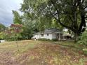 Quaint one-story home with covered side porch, lush trees, and spacious yard on an overcast day at 200 Walnut St, Cary, NC 27511