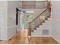 Bright foyer features wood floors, a staircase, and an arched doorway leading to other rooms at 2001 Dobson Ct, Raleigh, NC 27612