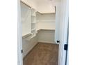Well-organized walk-in closet featuring custom shelving, carpet, and wooden closet rods at 204 Seahawk Way, Zebulon, NC 27597