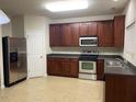 Traditional kitchen with dark wood cabinets, stainless steel appliances, and tile flooring at 21 Suncrest Ct, Durham, NC 27703