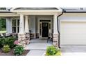 A close-up of the home's front porch with stone support columns and welcome decor at 212 Hardwick St, Clayton, NC 27527