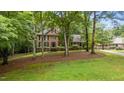This two-story brick home has a charming yard with mature trees and landscaping at 220 Dalton Dr, Raleigh, NC 27615