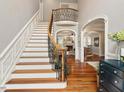 Grand foyer with a beautiful staircase, hardwood floors, and arched doorways at 2207 Cameron Pond Dr, Cary, NC 27519