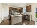 Modern kitchen with stainless steel appliances, a center island, tile backsplash, and dark wood cabinets at 225 Rosewood Ln, Youngsville, NC 27596