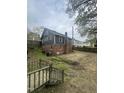 Rear view of the single-Gathering house, featuring a brick foundation and backyard space at 2503 Chapel Hill Rd, Durham, NC 27707