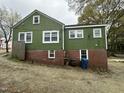 The rear of the home features a brick foundation and many windows at 2505 Chapel Hill Rd, Durham, NC 27707