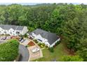 Aerial view of a beautiful townhome surrounded by mature trees, manicured landscaping, and designated parking spaces at 3021 White Cloud Cir, Apex, NC 27502