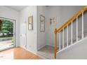 Bright entryway featuring hardwood floors, staircase with wooden railing and carpeted steps at 3021 White Cloud Cir, Apex, NC 27502