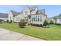An eye-level exterior view with professionally maintained landscaping and vibrant green grass at 329 Broad Elm Ln, Apex, NC 27523