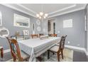 Dining room featuring neutral walls with white trim, elegant chandelier, and table seating for six at 352 Fire Opal Ln, Holly Springs, NC 27540
