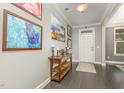 Inviting entryway featuring dark hardwood floors and stylish decor; gallery wall with paintings at 352 Fire Opal Ln, Holly Springs, NC 27540