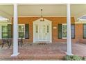 Inviting front porch featuring classic brickwork, white columns, and charming entryway at 3911 Hope Valley Rd, Durham, NC 27707
