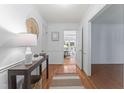 Bright hallway with hardwood floors, white trim, and a view into the living area at 3911 Hope Valley Rd, Durham, NC 27707