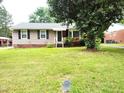 Well-kept front yard and charming single-story house with black shutters and a manicured lawn at 404 Oakgrove Dr, Graham, NC 27253