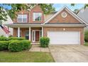 Traditional home with a two-car garage, red brick facade, and well-maintained greenery at 404 Straywhite Ave, Apex, NC 27539