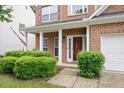 Inviting front entrance with red door, classic white columns, and lush green landscaping at 404 Straywhite Ave, Apex, NC 27539