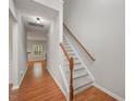 Bright hallway with hardwood floors, carpeted stairs, and access to multiple rooms at 404 Straywhite Ave, Apex, NC 27539